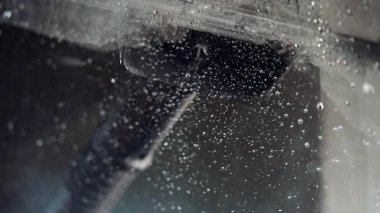 Duş kabinindeki cam, özel bir kauçuk fırça ve büyük miktarda su kullanılarak yıkanır..