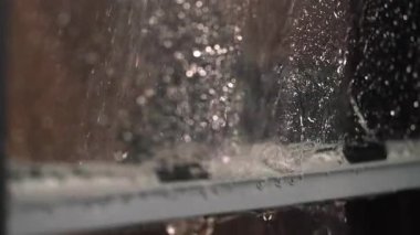 Lastik kazıyıcı ve duş başlığı kullanmak cam yüzeyleri yıkamak için bir yöntemdir..