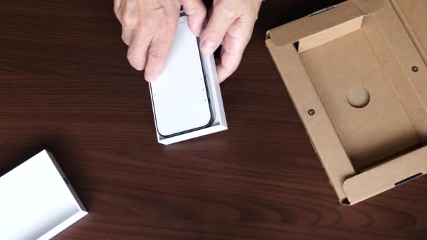 Fechar Mãos Homem Tirando Novo Smartphone Caixa Removendo Lentamente Protetor — Vídeo de Stock