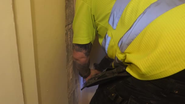 Werknemer Draagt Felgele Kleur Veiligheidsvest Shirt Breekt Gips Van Binnenwand — Stockvideo