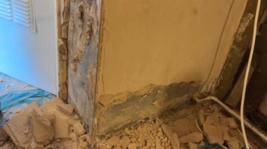 SDS matkabı ve keskiyle iç duvardan eski alçıyı kaldıran bir adam evin içinde bir sürü toz, yavaş çekim, el kamerası görüntüsü..