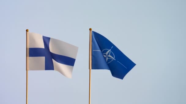 Natoとフィンランドの孤立した旗は それほど白い背景ではなく パートナーシップの象徴に対して振っています スローモーション コピースペース — ストック動画