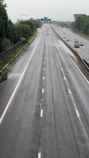 Manchester England イギリス 2023 垂直ハンドヘルドビデオ マンチェスターのM60スマート高速道路上の雨 救急車のバンやその他の輸送運転 上からのトラフィックビュー — ストック動画
