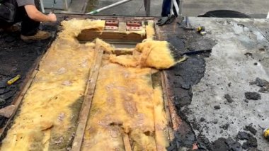 Adamım, profesyonel çatı ustası eski çivileri söküyor ya da çekiçliyor. Düz çatıdaki su kontrplak çarşafının hasarını değiştirmek için..