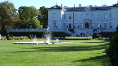 Uzak insanlar Palanga tatil köyü parkında güneşli bir yaz gününün tadını çıkarıyorlar..