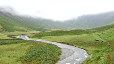 İngiltere 'nin Lake District Ulusal Parkı' ndaki manzara çok güzel. Mosedale Beck dağ deresi alçak bulutların altında, statik yüksek çekim.