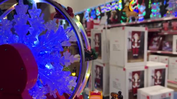 クリスマスの装飾百貨店で回転する青いクリスマスの雪片の車輪の輝きの近く 前景に選択的な焦点 — ストック動画