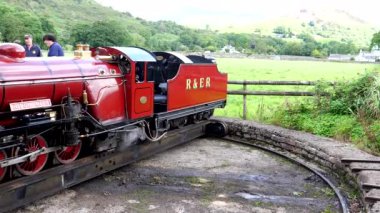 Dar göstergelerin sonunda minyatür buhar treni servis ekibi buhar makinesini veya lokomotifi elle çeviriyor. Eskdale, Lake District Ulusal Parkı, Birleşik Krallık.