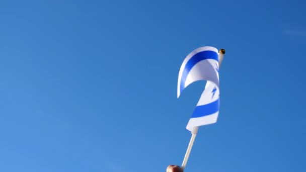 Mão Acenando Bandeira Israelense Contra Céu Azul Claro Vista Close — Vídeo de Stock