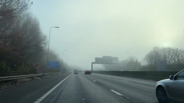 M60モーターウェイの冬の霧で運転する車の風景ビュー マンチェスター市のリングロード イギリス — ストック動画