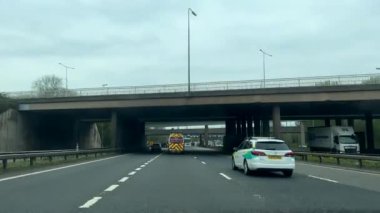 Manchester, Birleşik Krallık. Köprülerin altından M60 otoyolu geçiyor. Yol hız sınırlama levhasında olay, kanat açıklığıyla aydınlandı. Arabanın ön cam görüntüsü.