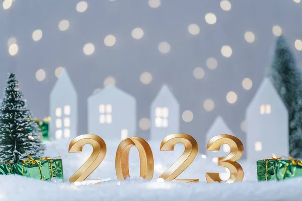 2023年的金牌数在淡淡的背景上放上带有Bokeh的节日花环 祝您新年快乐 舒适的氛围 有可爱的小房子 背景是雪地里的树 — 图库照片