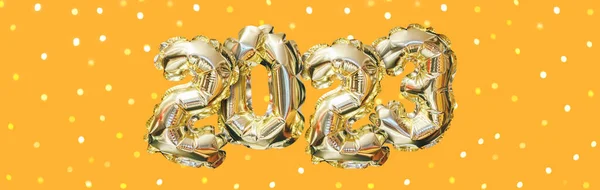 2023年のヘリウム黄金の気球の数 オレンジを背景にボケでお祝いのガーランドを育てる ハッピーニューイヤーバナー — ストック写真