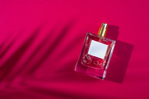 Transparante Fles Parfum Met Etiket Rode Achtergrond Parfumpresentatie Met Daglicht — Stockfoto