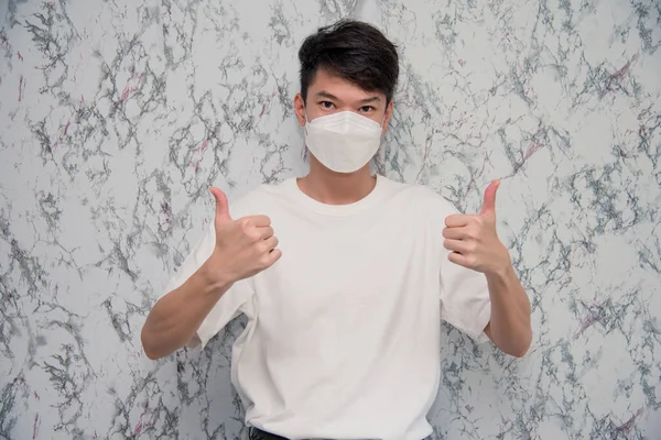 Young Man Puts Face Mask Showing Thumbs Looking Serious Isolated — Fotografia de Stock