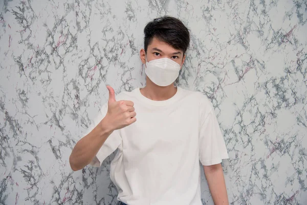 Young Man Puts Face Mask Showing Thumbs Looking Serious Isolated — ストック写真