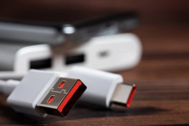 Mobil cihazları şarj etmek için USB kablosu ve akıllı telefonu olan taşınabilir güç bankası.