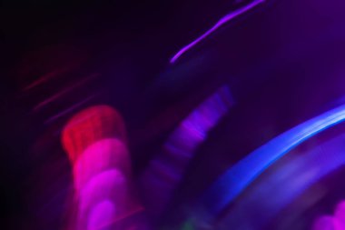Bulanık neon ışık. Mercek alevi kaplaması. Bokeh floresan flaş parıltısı. Koyu siyah soyut arkaplanda odaklanmış mavi mor renk lekeleri.