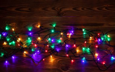 Noel ışıkları arka plan, kopya alanı. Kahverengi ahşap plakalar yüzeyi tatil parlak garland sınır üstten görünüm. Xmas ağacı süslemeleri, kış tatil aydınlatma