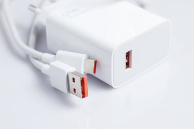 Beyaz arka planda USB kablosu olan beyaz şarj aleti