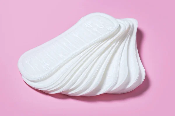 Feminine hygiene pads on a pink background. Concept of feminine hygiene during menstruation