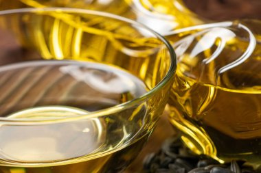 Şişe içinde ayçiçeği yağı ve ahşap zemin üzerinde cam kase.