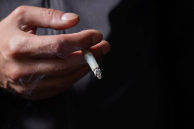 sigara yakma ile el ve siyah arka plan üzerine duman.