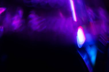 Bulanık neon ışık. Mercek alevi kaplaması. Bokeh floresan flaş parıltısı. Koyu siyah soyut arkaplanda odaklanmış mavi mor renk lekeleri.