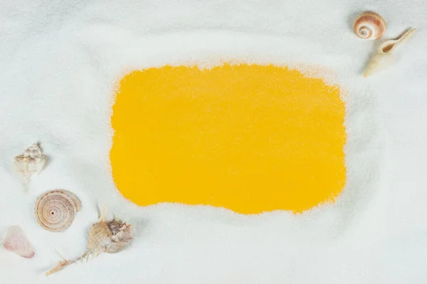 白い石英砂と黄色の背景のシェルからの砂のフレーム — ストック写真