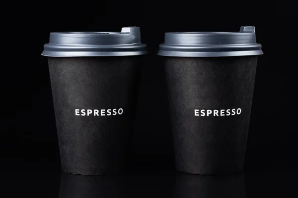two black paper coffee cup isolated on black background.