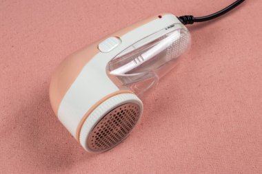 Machine for removing pellets. A special device to remove lint from clothes. Restoration of old damaged clothes