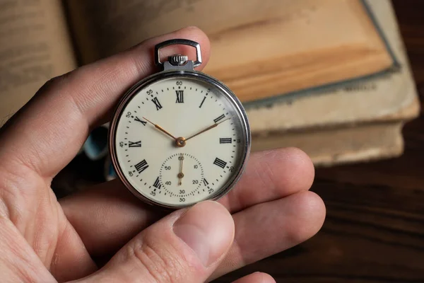 close up of hands with vintage pocket watch retro.