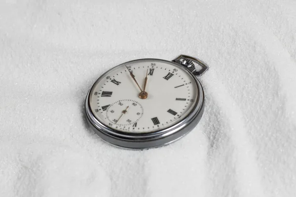 Pocket watch buried in sand. Old watch lost in the sand