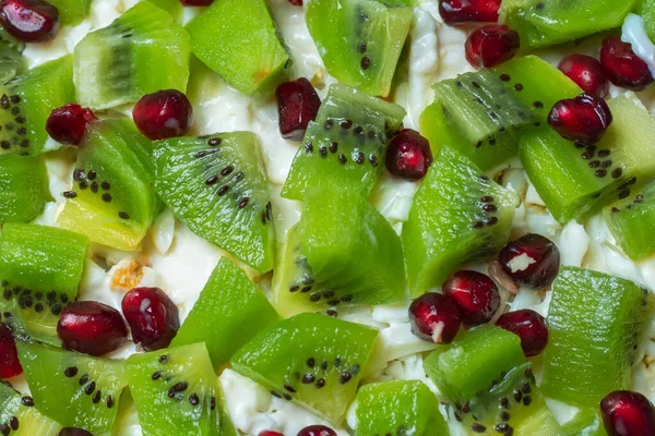 Healthy fruit salad kiwi and pomegranate close up.