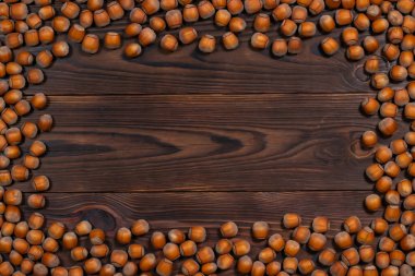 Kahverengi tahtalarda kabukları olan bir sürü fındık çerçevesi..