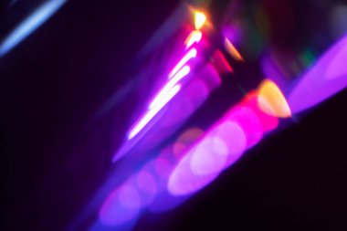 Bulanık neon ışık. Mercek alevi kaplaması. Bokeh floresan flaş parıltısı. Koyu siyah soyut arkaplanda odaklanmış mavi mor renk lekeleri.