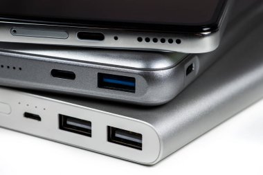 Powerbank for charging mobile devices on white. Smartphone with power bank. External battery for mobile devices.