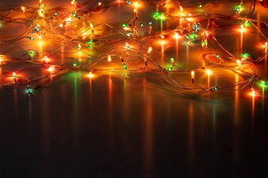 Christmas garland lights on dark background copy space.