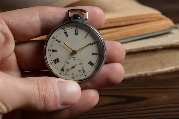 close up of hands with vintage pocket watch retro.