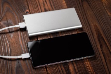 Powerbank ve akıllı telefonu ahşap masaya yükle.