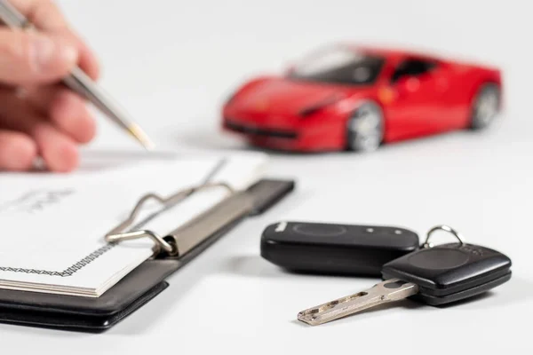 Autoschlüssel Auf Dem Schreibtisch Hintergrund Unterschreibt Ein Mann Kaufdokumente Nahaufnahme — Stockfoto