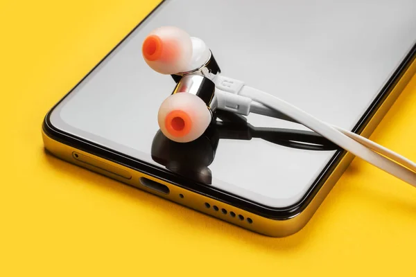 Sarı Arka Planda Akıllı Telefon Kulaklık Kapat — Stok fotoğraf