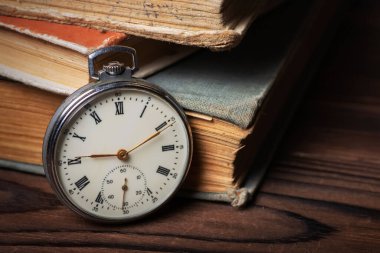 Old vintage watch on books background close up.