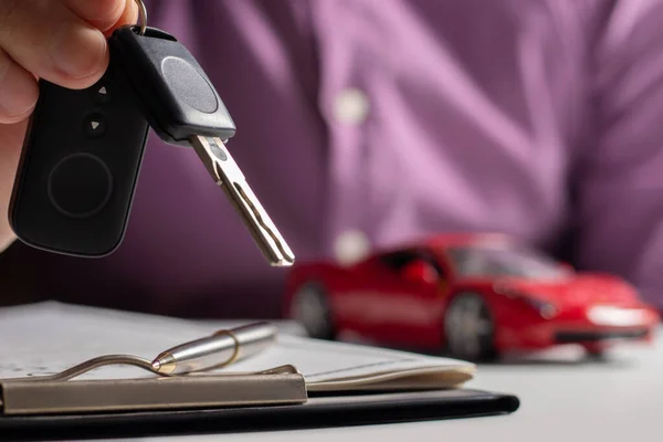 保险官员把车钥匙交给了房客 签署了汽车保险文件或租约或协议书购买或销售新车或二手车 — 图库照片