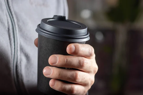 Stock image Man drinking coffee from disposable cup with cocktail tube close up.