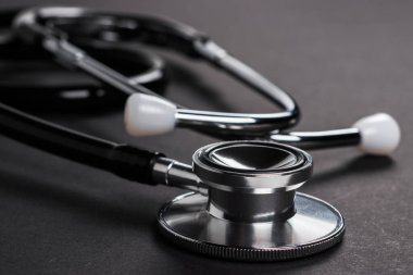 Karanlık arka planda siyah steteskop. Sağlık hizmetleri polisi