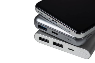 Powerbank for charging mobile devices on white. Smartphone with power bank. External battery for mobile devices.