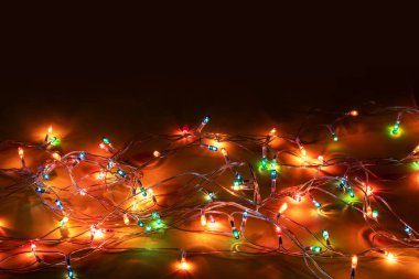 Christmas garland lights on dark background copy space.