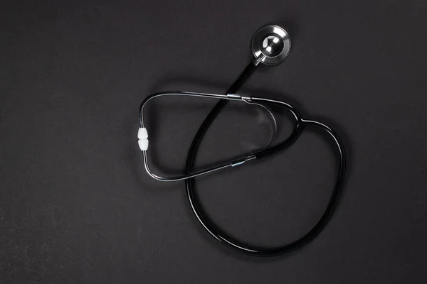 暗い背景に黒い聴診器 医療の概念 — ストック写真