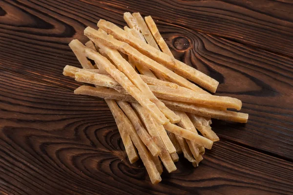 stock image Close-up of dried salted tuna stripes on wooden background. Beer snacks, restaurant menu, salty seafood.